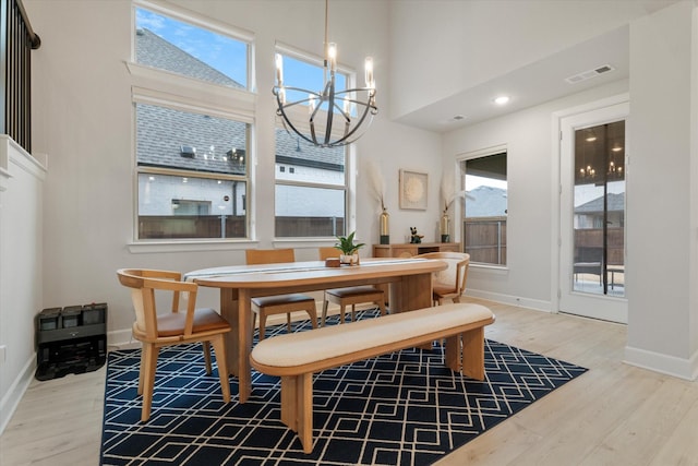 dining room with a high ceiling, hardwood / wood-style floors, and a notable chandelier