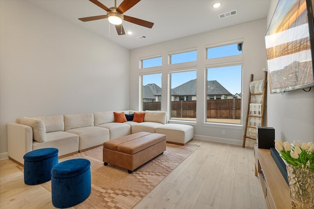 living room with ceiling fan and light hardwood / wood-style flooring