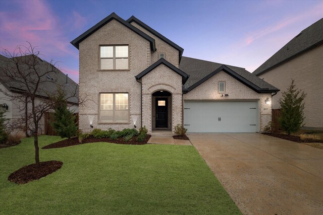 view of front of property featuring brick siding, a shingled roof, concrete driveway, a lawn, and an attached garage