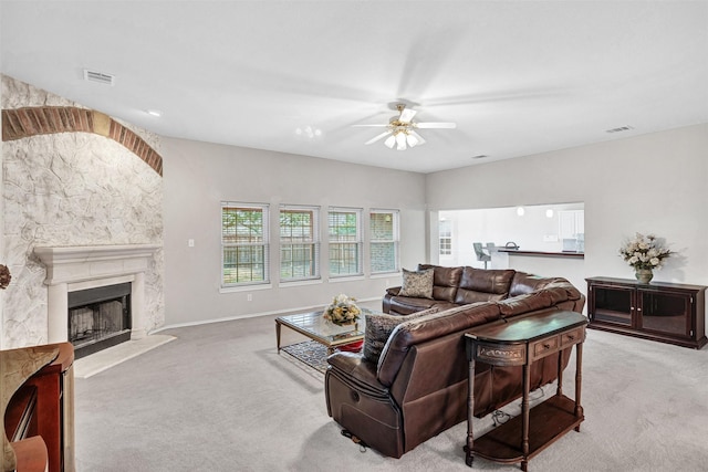 living room featuring light carpet, ceiling fan, and a premium fireplace