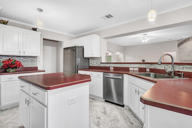 kitchen featuring a center island, sink, appliances with stainless steel finishes, white cabinets, and pendant lighting