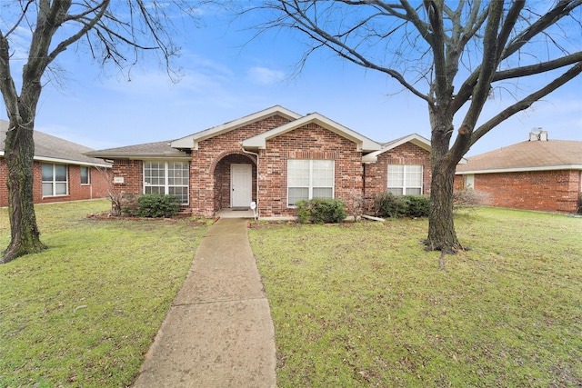 ranch-style house with a front lawn and brick siding