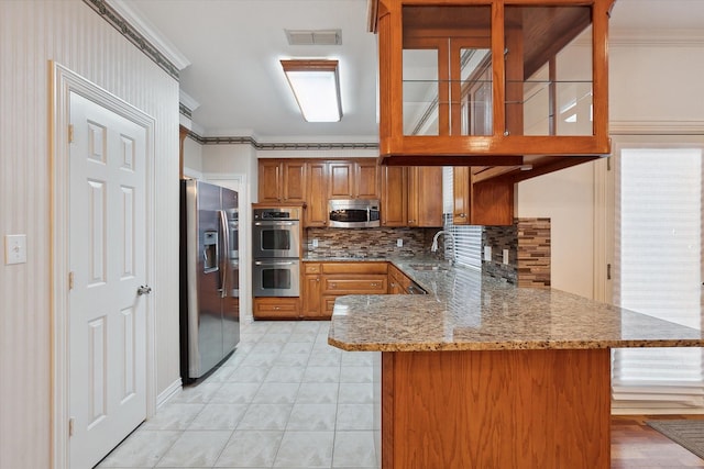 kitchen featuring sink, crown molding, stone countertops, appliances with stainless steel finishes, and kitchen peninsula