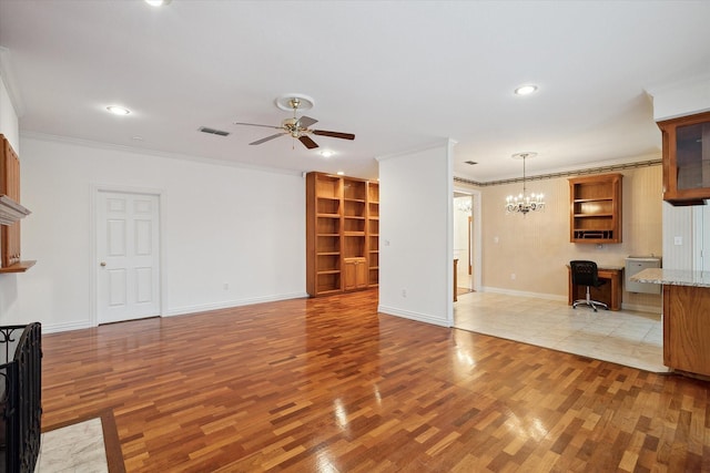 unfurnished living room with ornamental molding, built in desk, ceiling fan with notable chandelier, and light wood-type flooring