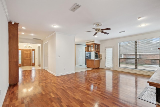 unfurnished living room with crown molding, light hardwood / wood-style flooring, and ceiling fan with notable chandelier