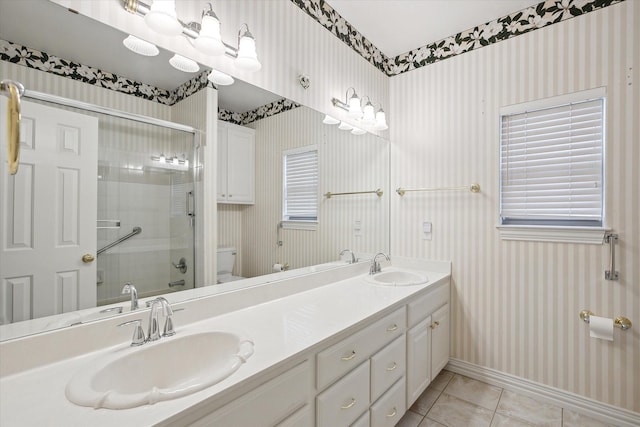 bathroom with vanity, toilet, a shower with door, and tile patterned flooring