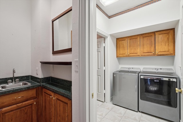 laundry room with sink, light tile patterned floors, cabinets, and independent washer and dryer