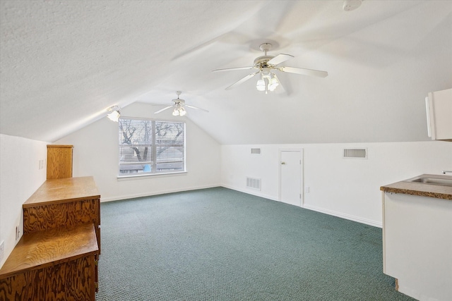 bonus room featuring visible vents, a ceiling fan, and dark carpet