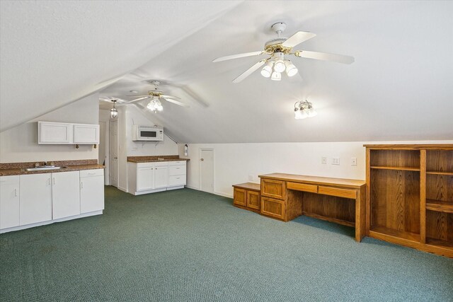 bonus room featuring ceiling fan, lofted ceiling, a textured ceiling, and dark carpet