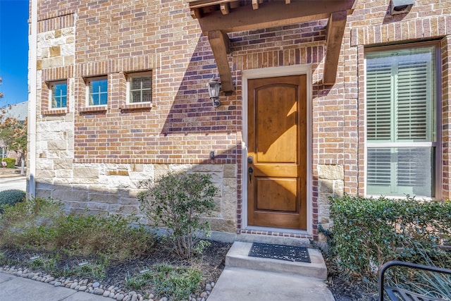 entrance to property featuring brick siding