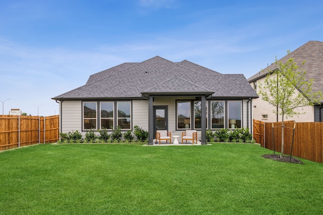 back of property with a yard and a patio area