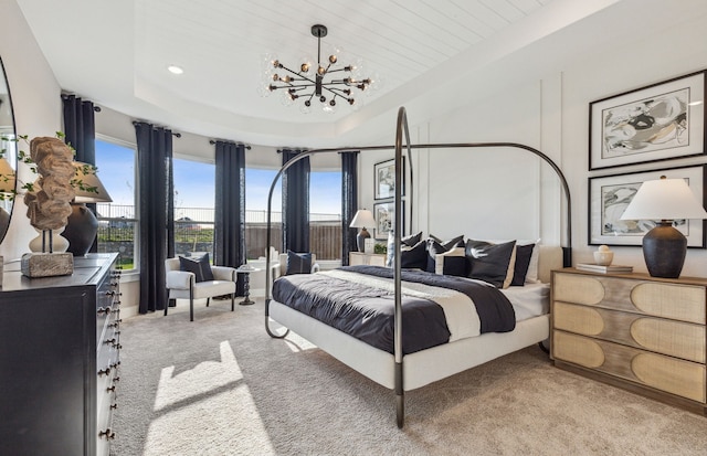 bedroom featuring light carpet, a raised ceiling, and a chandelier