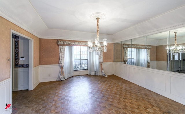 unfurnished dining area featuring a notable chandelier, a tray ceiling, parquet flooring, and a healthy amount of sunlight