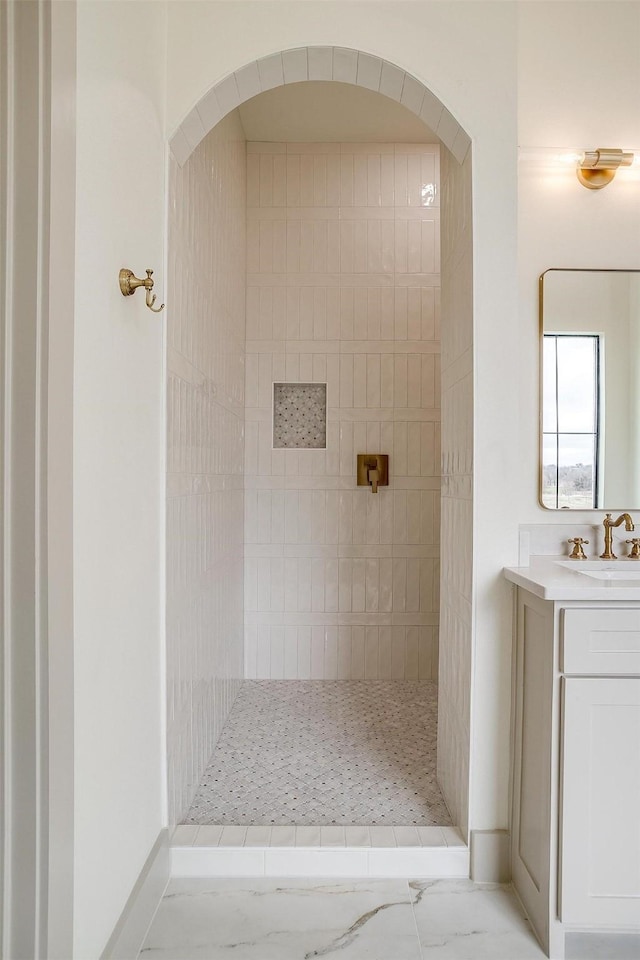 bathroom featuring a tile shower and vanity