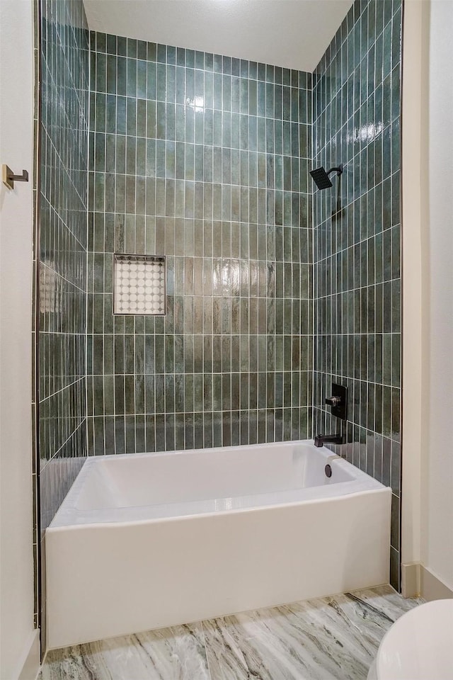 bathroom featuring tiled shower / bath and toilet