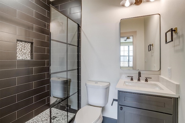 bathroom featuring tiled shower, vanity, and toilet