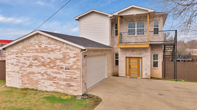 view of front facade featuring a garage, driveway, brick siding, and stairs