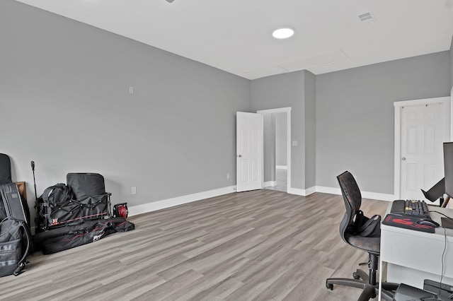 office space featuring light wood-type flooring, visible vents, and baseboards