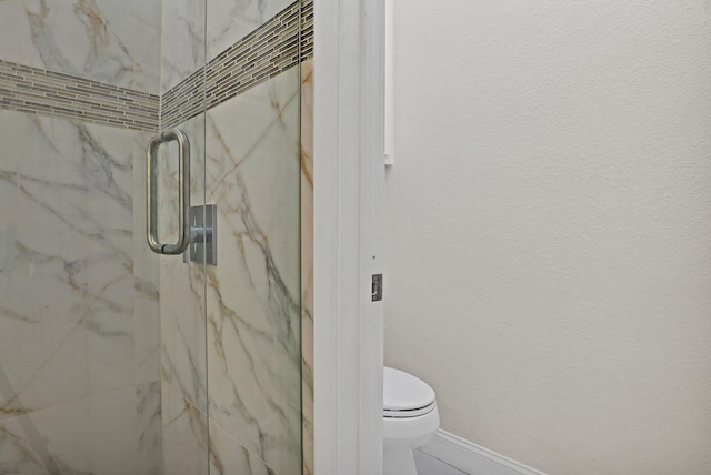 bathroom featuring an enclosed shower and toilet