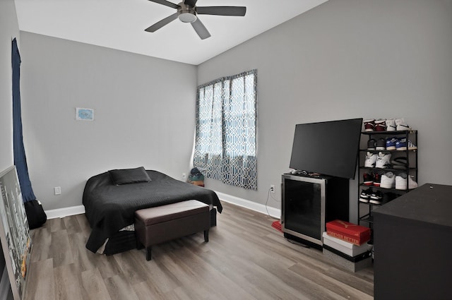 bedroom with ceiling fan, baseboards, and wood finished floors