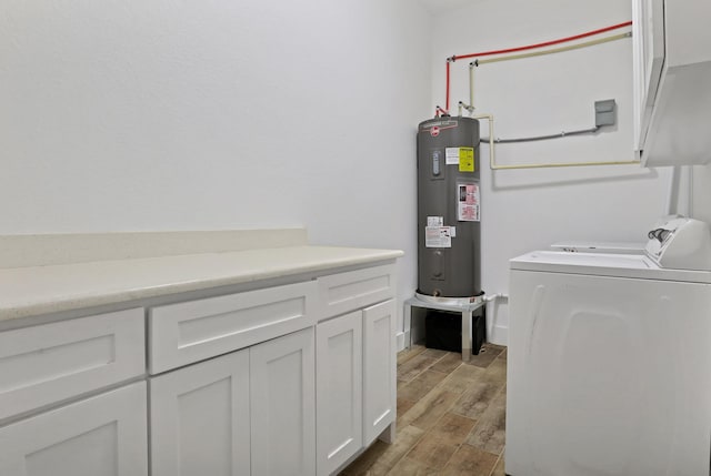 washroom with electric water heater, washing machine and dryer, cabinet space, and wood tiled floor