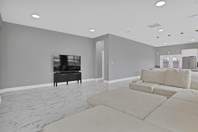 living area with marble finish floor, visible vents, and baseboards