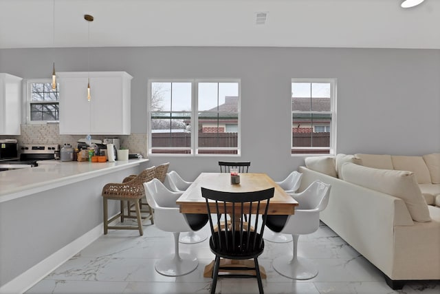 dining space featuring marble finish floor, visible vents, and baseboards