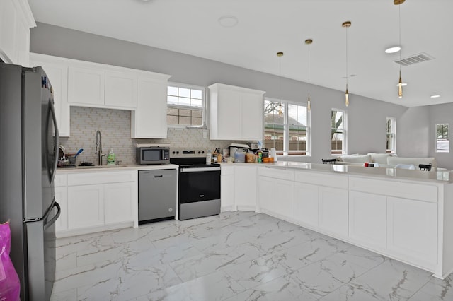 kitchen with pendant lighting, marble finish floor, stainless steel appliances, light countertops, and visible vents