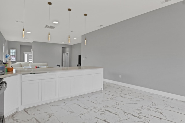 kitchen featuring visible vents, white cabinets, open floor plan, decorative light fixtures, and marble finish floor