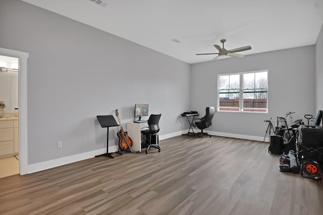 office featuring light wood-style flooring, visible vents, baseboards, and ceiling fan