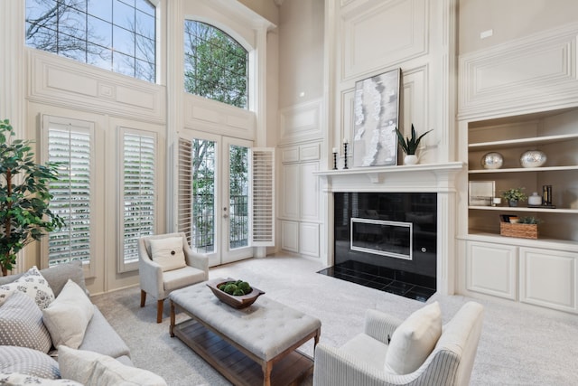 living room featuring a high ceiling, a healthy amount of sunlight, and built in shelves