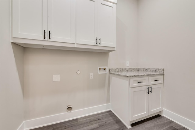 clothes washing area featuring dark wood-type flooring, cabinets, and washer hookup