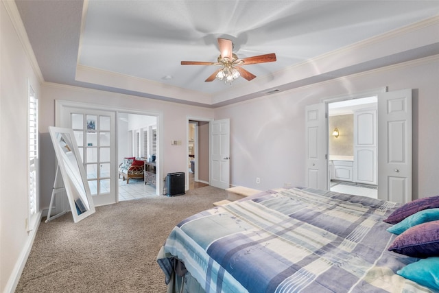 bedroom with french doors, ensuite bath, ornamental molding, a tray ceiling, and light colored carpet