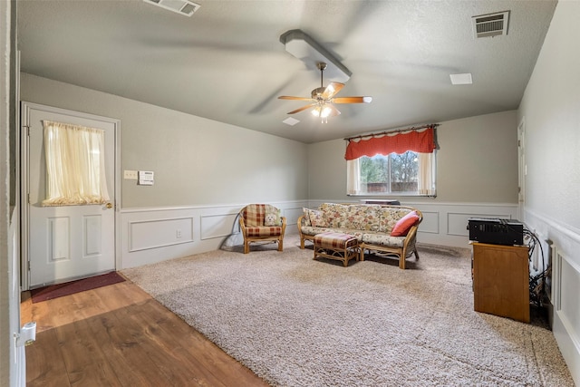 living area featuring vaulted ceiling, a textured ceiling, and ceiling fan