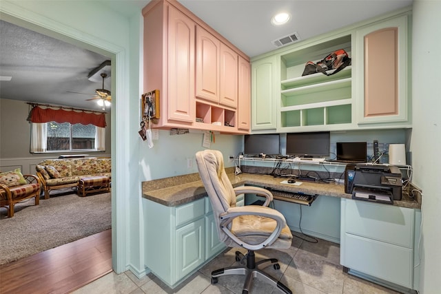 home office featuring built in desk and ceiling fan