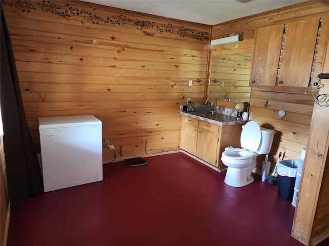 3929 San Saba St, Athens, TX 75752 - bathroom featuring toilet, wood walls, and vanity