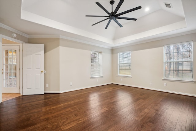 empty room featuring wood-type flooring, ornamental molding, a raised ceiling, and ceiling fan