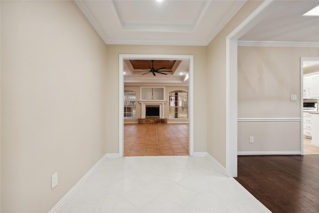 corridor featuring crown molding, wood-type flooring, and a raised ceiling