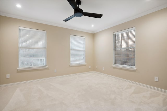 carpeted spare room featuring crown molding and ceiling fan