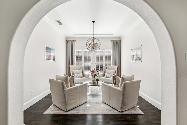 living area with baseboards, crown molding, arched walkways, and wood finished floors