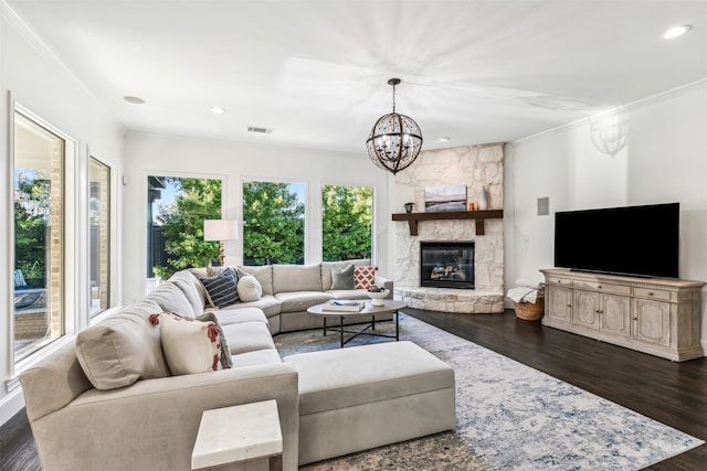 living room featuring crown molding, recessed lighting, dark wood finished floors, and a stone fireplace