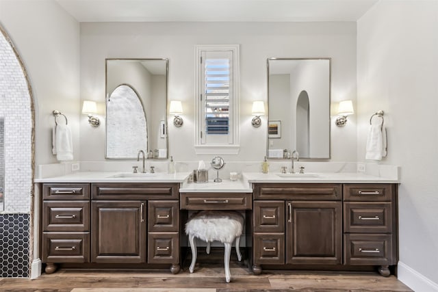 bathroom featuring double vanity, a sink, and wood finished floors