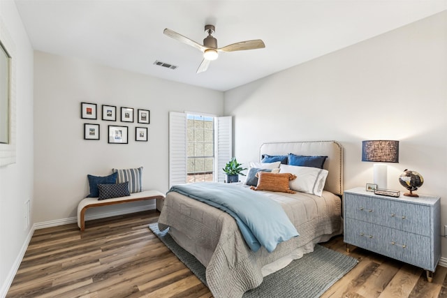 bedroom featuring baseboards, visible vents, ceiling fan, and wood finished floors