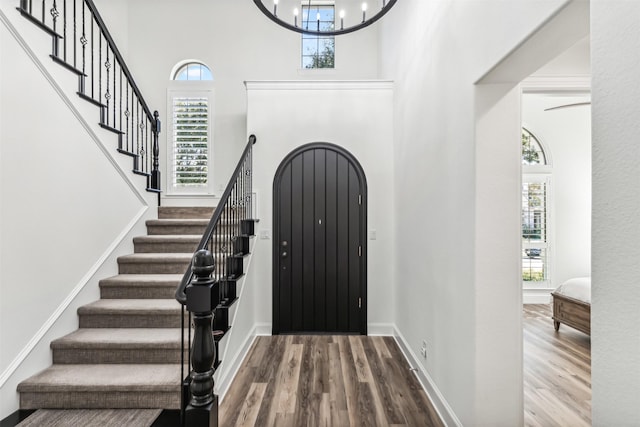 foyer featuring plenty of natural light, arched walkways, and wood finished floors