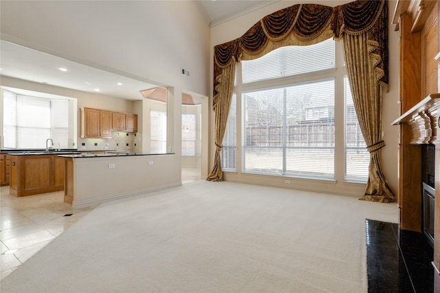 living area featuring recessed lighting, a towering ceiling, a wealth of natural light, and light colored carpet