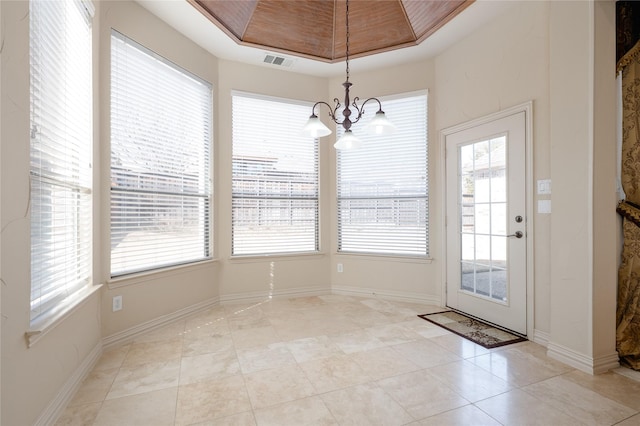 unfurnished dining area with an inviting chandelier, baseboards, visible vents, and a raised ceiling