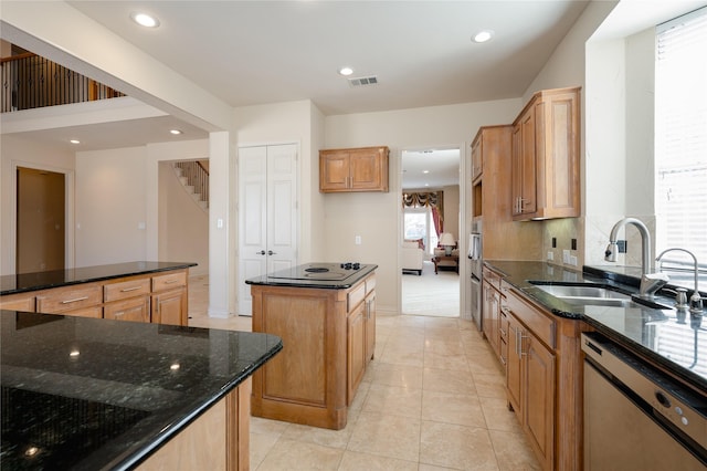 kitchen with dark stone counters, a sink, visible vents, a center island, and dishwasher