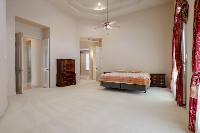 bedroom with recessed lighting, light colored carpet, a towering ceiling, a raised ceiling, and crown molding