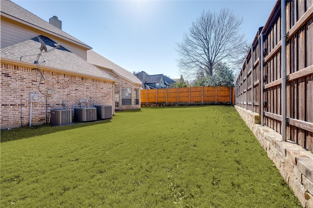 view of yard featuring a fenced backyard and central AC unit