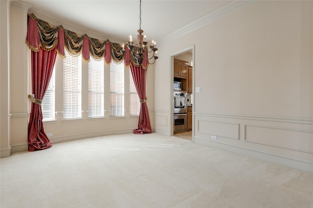 empty room featuring a chandelier, a decorative wall, carpet, and crown molding